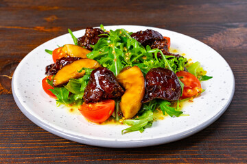 Delicious salad with fruits and a rich sauce on a white plate Savory vegetable pie served with fresh garnishes on a white plate