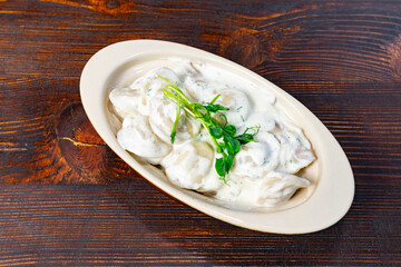 Delicious dumplings served in creamy sauce on rustic wooden table Savory vegetable pie served with fresh garnishes on a white plate