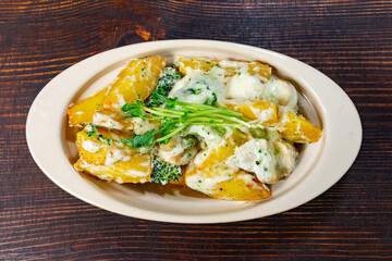 Delicious creamy potato dish with broccoli served in rustic setting Savory vegetable pie served with fresh garnishes on a white plate