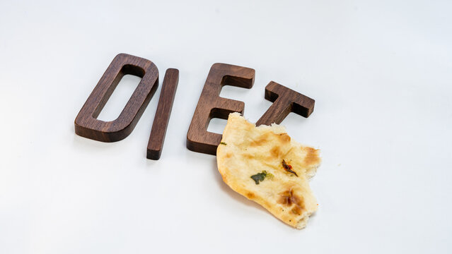 Word "DIET" wooden letters with rotti or peice of pizza  isolated on white background