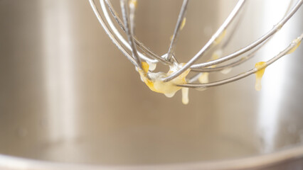 Beating eggs with an electric mixer close up.