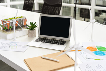 Table in the office with laptop and project documentation on