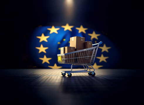 A shopping cart filled with cardboard boxes sits under a spotlight against a blurred European Union flag backdrop.  This symbolizes EU trade and commerce.