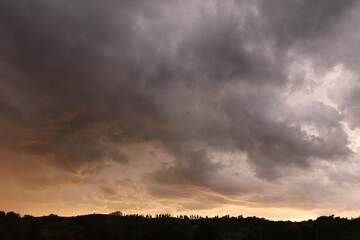 panorama al tramonto con alberi e cielo rosso e nuvole