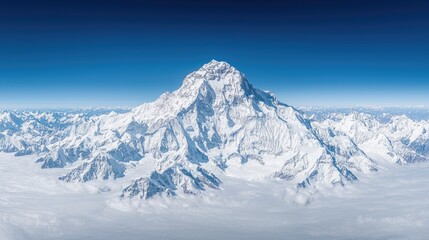 Obraz premium Majestic snow-covered mountain peak rising above a sea of clouds under a clear blue sky.