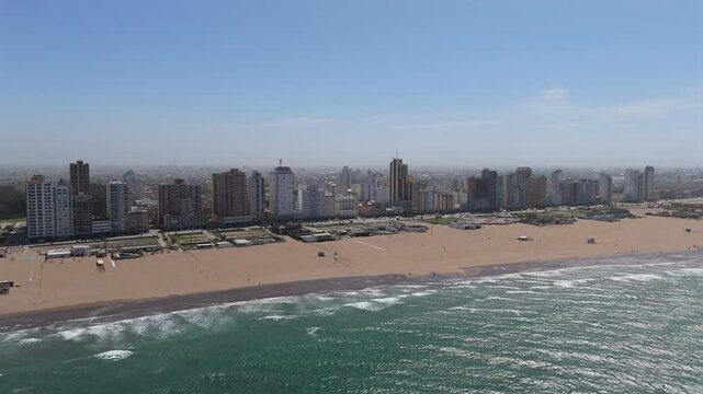 Smooth receding aerial movement from the Nechochea coastal city beachfront, Argentina.