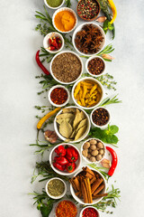 A beautiful display of cooking spices and dried herbs on a gray background, offering a palette of natural hues ideal for culinary inspiration