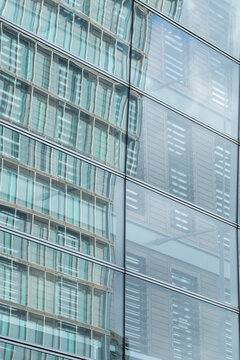 An artistic image showcasing the abstract reflection of multiple buildings on a glass facade, illustrating the beautiful complexity of modern architecture in urban life.