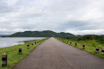  long road through a quiet reservoir in the countryside with mountains and beautiful nature