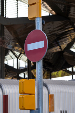 A prominent red no entry sign mounted on a pole, surrounded by reflective yellow lights, highlighting traffic rules and safety in urban settings for pedestrians and drivers.