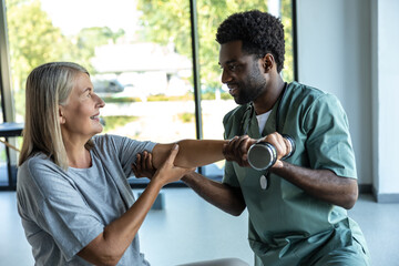 Chiropractor consulting adult patient for recovery after injury through rehabilitation