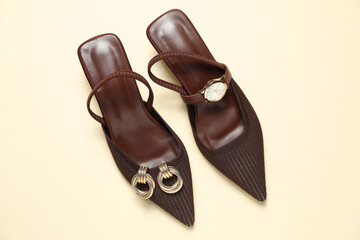 Stylish women's shoes, golden earrings and watch on beige background, top view