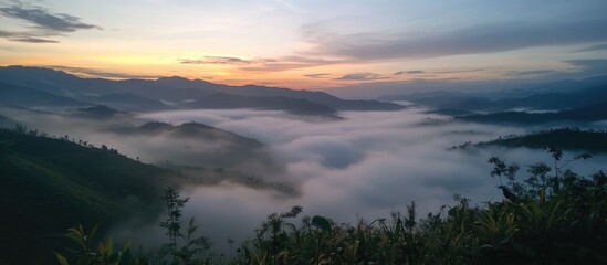Fototapeta premium Scenic view of hills covered with fog during sunrise