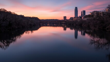 Fototapeta premium Serene urban sunset reflecting on calm water surface.
