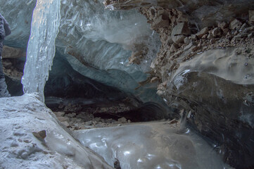  Interior of glacial cave with ice formations and rocky floor