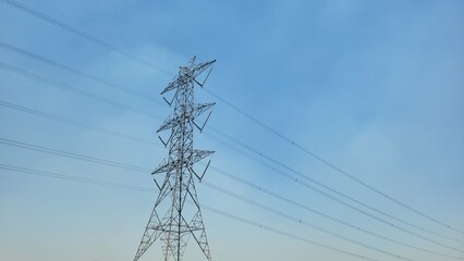 High Voltage Power Transmission Tower Against a Clear Blue Sky
