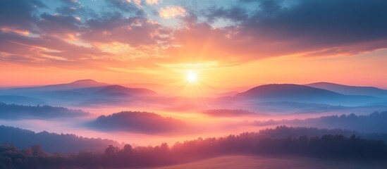 Obraz premium Majestic sunrise over misty mountain landscape.