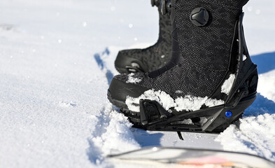 Snowboarder is preparing for riding down the snowy slope on a sunny winter day
