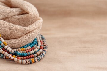 Obraz premium Vibrant beaded necklace displaying intricate patterns on a soft neutral background creating a stunning visual appeal