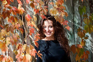 Woman hair care. Woman portrait outdoor. Autumn leaves and young girl. Millennial woman in autumn park. Fall portrait. Girl in autumn style has curly hair. Fall girl style fashion. Happiness