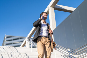 Successful Businessman Walking In Urban Environment, Talking On Phone And Descending Stairs From...