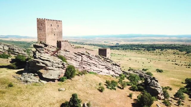 Castillo de Zafra stands atop a rugged rocky outcrop in Spain's vast countryside, showing medieval architecture and panoramic landscapes that highlight its cultural and geographical significance
