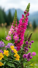 Obraz premium A vibrant display of colorful flowers in a lush green field, set against a backdrop of mountains under a cloudy sky.