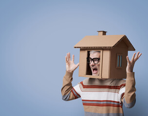 Desperate homeowner with cardboard house on his head