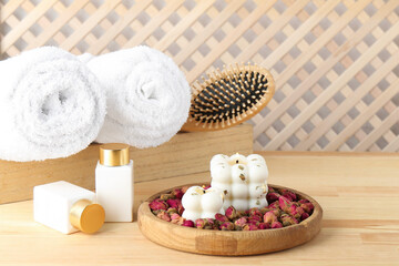 Composition with towels and cosmetic products for spa treatment on wooden table