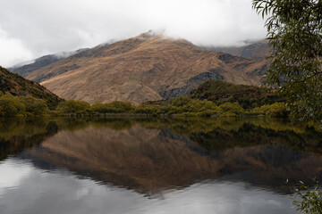 Countryside of New Zealand with a cloud-covered mountain at Diamond Lake in Wanaka (South Island, New Zealand)