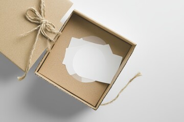 Open cardboard gift box with blank cards and twine.