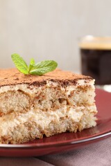 Delicious tiramisu with mint on table, closeup