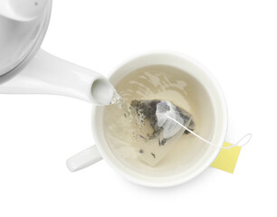 Pouring hot water into cup with tea bag on white background, top view