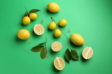 Lemon zest, fresh fruits and leaves on green background, flat lay
