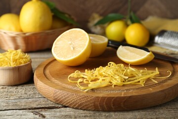 Lemon zest, tools and fresh fruits on wooden table, closeup