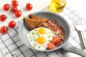 Tasty fried eggs with bacon and toasts served on white table, closeup