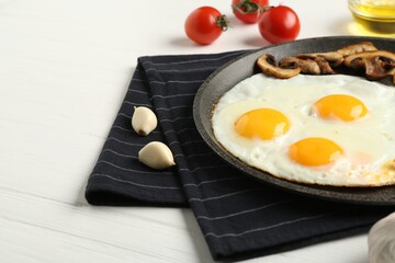 Tasty fried eggs with mushrooms served on white wooden table, closeup. Space for text