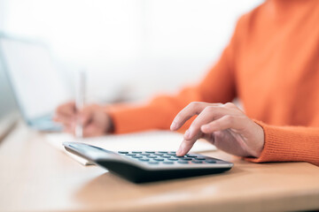 Close up woman hand using calculator. Doing finance, budgeting and tax calculation, monthly...