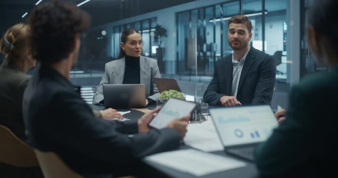 Portrait of an Expert Analyzing Data and Sharing Insights During a Meeting with Partners in a Modern Glass Meeting Room. Managers Identifying Trends, Business Challenges and Development