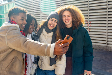 Group of students taking selfie with smartphone outside college building
