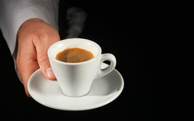 Hand with coffee cup on black background