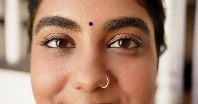 Close-up of Indian woman with nose ring and bindi smiling confidently
