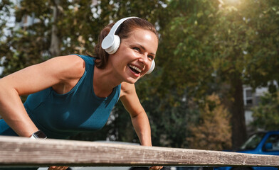 Naklejka premium Healthy and happy young woman exercising outdoors using street bench.