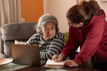 elderly woman working with her daughter at the computer