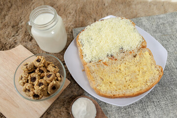 Bread with cheese, sweetened condensed milk, and butter. With white milk and snack on a table for breakfast	
