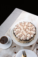 Kyiv cake with nuts, buttercream on a white cake plate, yellow runner, white dishes, espresso...