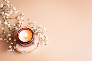 Burning candle and white gypsophila flowers