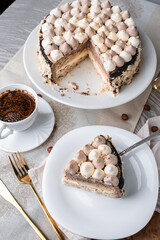 Kyiv cake with nuts, buttercream on a white cake pan in a cut on a white plate, espresso coffee, gold cutlery, Ukrainian desserts, nut cake, flatlay