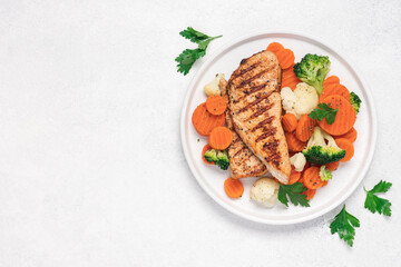Grilled chicken breast and broccoli, cauliflower and carrots. Chicken meat with vegetables. Healthy food. White background top view