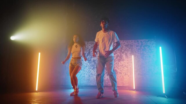 Full-length portrait of two African dancers in rehearsal hall of dance studio. Dancers performing contemporary moves in studio, filled with vibrant energy and rhythmic beats, music and enthusiasm